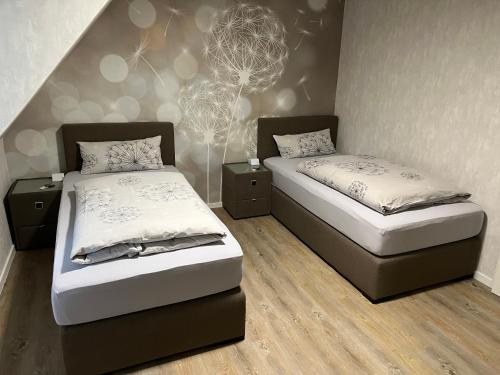 施塔德Peedy's luxuriöse 60m² Wohnung mit Balkonterrasse的一间卧室设有两张床和一堵墙