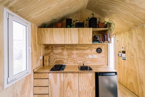 巴尔内阿利奥埃尔康多尔Loyca Eco-Tiny House的一个小房子里的厨房,有窗户