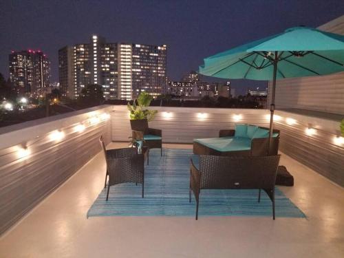 费城THE ROOFTOP OASIS的屋顶露台配有桌椅和遮阳伞。