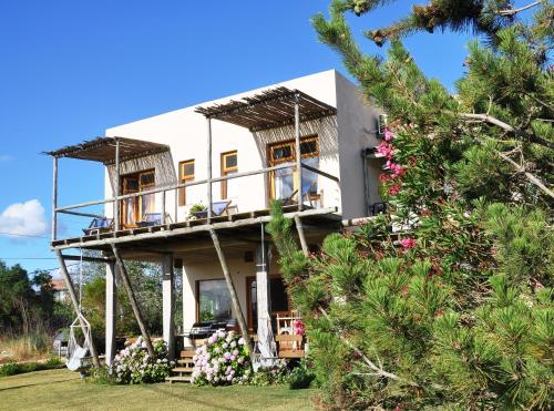 何塞伊格纳西奥海尔劳住宿加早餐旅馆的带阳台的房屋,庭院里种着鲜花