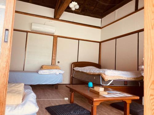 日南Guesthouse Nichinan - Vacation STAY 82913v的一间设有两张床和一张桌子的房间