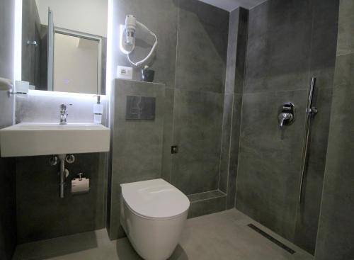萨兰达Art De Jon Rooms的带淋浴、卫生间和盥洗盆的浴室