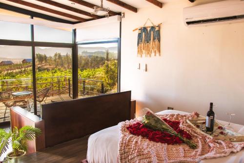 瓜达鲁佩镇Brisa Del Valle Hotel Boutique的卧室配有一张床,享有葡萄园的景色