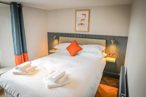 FlookburghHope and Anchor的卧室配有带橙色枕头的大型白色床