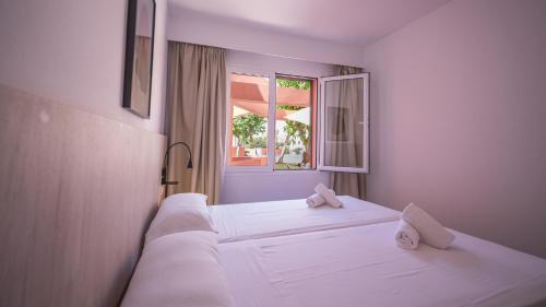 卡拉恩·布拉內斯Sant Joan Apartaments - Adults Only的一间卧室设有两张白色的床和窗户