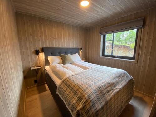 松达尔Hytte i Sogndal med panoramautsikt的一个小房间的一个床位,设有窗户