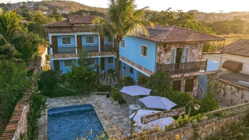 皮雷诺波利斯POUSADA CARVALHO的享有带游泳池和遮阳伞的房屋的空中景致