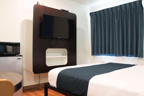 雷克斯堡Motel 6 Rexburg, ID的配有一张床和一台平面电视的酒店客房