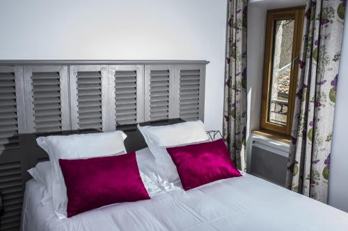 拉尔邦克La Tissandière的卧室配有一张白色床和两个紫色枕头