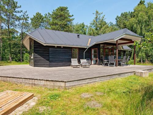 罗莫柯克比8 person holiday home in R m的小木屋设有甲板和庭院