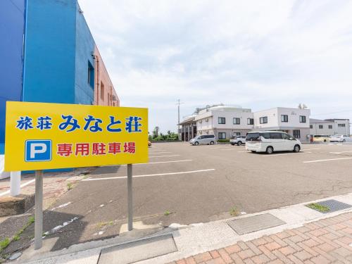 NaoetsuTabist Ryosou Minatosou Joetsu的停车场内有一个黄色标志的停车场