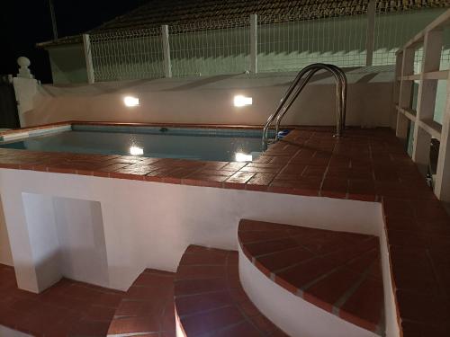 Vila NovaCasa dos Pedro´s的一座大楼的顶部,设有一座带热水浴缸的游泳池