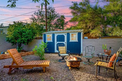 土桑Peaceful Tucson Tiny House Getaway with Backyard的后院设有蓝色的棚子、椅子和火坑