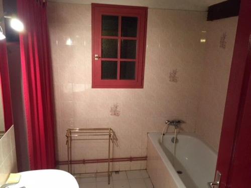 CoullonsGîte Coullons, 4 pièces, 6 personnes - FR-1-590-18的一间带红色窗户和浴缸的浴室