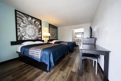 圣奥古斯丁海滩Ocean Breeze Inn的酒店客房设有两张床和一张带电脑的书桌