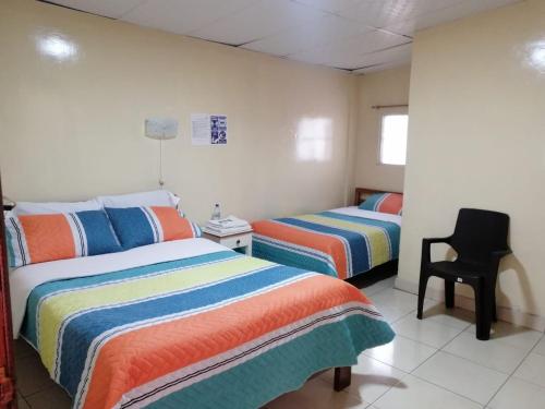 伊瓦拉Hostal Cumbres Andinas的一间卧室配有两张床和椅子