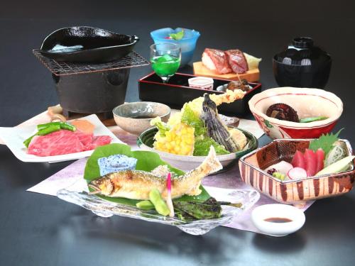 恵那市图塔洛日式旅馆 的餐桌,盘子上放着食物和碗
