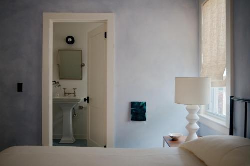 布拉德利比奇The James Bradley的一间卧室配有床、水槽和镜子