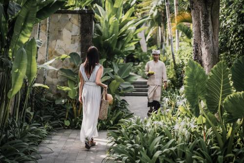 坎古The Retreat at Kharista by Ekosistem的穿白色衣服的女人穿过花园