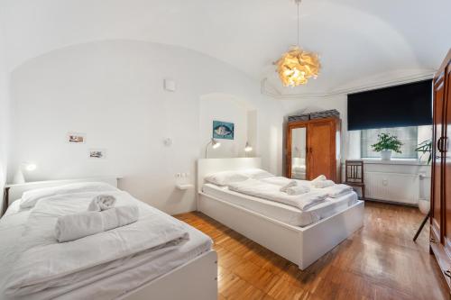 卢布尔雅那ROG Apartment with Furnished Courtyard的一间卧室配有两张床和吊灯。