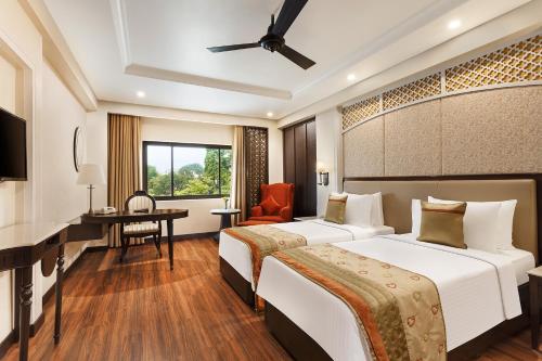勒克瑙拉普诶斯珀尔提克萨罗瓦尔酒店的酒店客房配有两张床和一张书桌