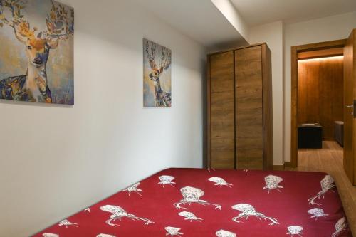 摩德纳迪-坎皮格里奥Chalet 5 Laghi / LuxApt / Town Centre的卧室配有红色的床,墙上挂着鹿的照片