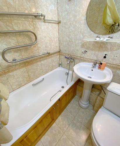 阿拉木图Апартаменты аэропорт的带浴缸、盥洗盆和卫生间的浴室