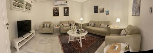 利雅德سمو 2的带沙发、桌子和电视的客厅