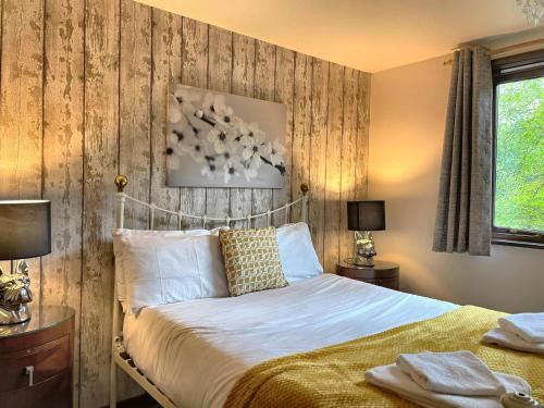 卡马森Wren 23-Hot Tub-Woodland Lodges-Tenby-Pembroke的一间卧室配有一张木墙床