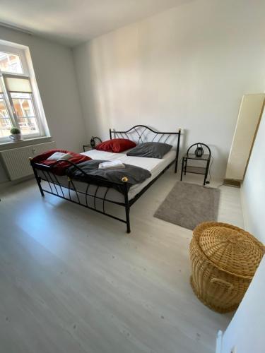 利希滕斯泰因Stadtdomizil的卧室配有一张床和一个篮子,位于地板上