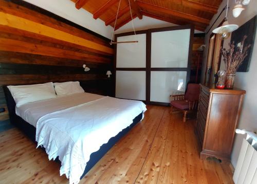 Trieste for you with Nature&Hiking的铺有木地板的客房内设有一间卧室和一张床。