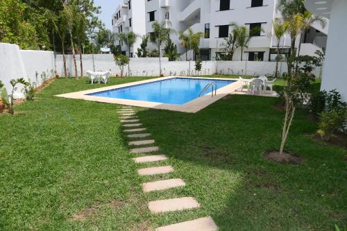 卡博尼格洛Hôtel Corail de Cabo的一个带游泳池和草地庭院的后院