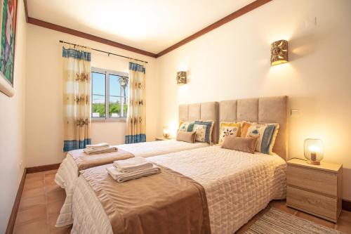 拉戈阿Casa Benagil Mar的一间卧室设有一张大床和一个窗户。