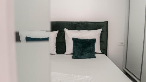 康斯坦察Toto’s Apartment的一张带两个枕头的白色床和绿色床头板