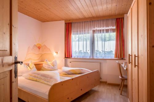 科尔皮缇亚Gamperhof Apartment Latemar的一间卧室设有一张床和一个窗口