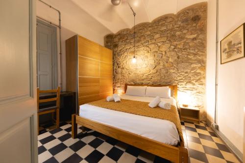 赫罗纳Bravissimo Les Rajoles, Unique 3-bedroom apartment的一间卧室设有一张床和石墙