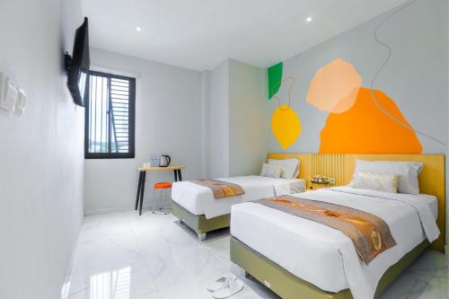 美娜多Genio Inn - MANTOS的酒店客房设有两张床和橙色的墙壁。