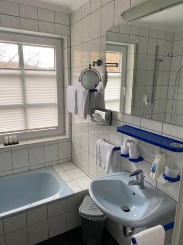 兰施图尔兰施图尔斯湖洛斯酒店的一间带水槽、浴缸和镜子的浴室