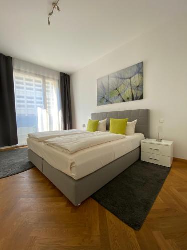 德累斯顿grosszügiges Apartment mit Blick zur Frauenkirche的白色卧室配有一张带黄色枕头的大床