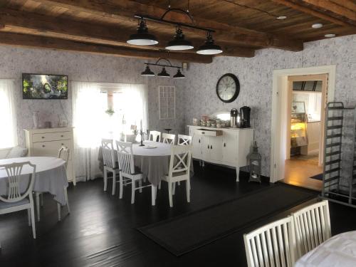 海勒福什Bredsjö Gamla Herrgård White Dream Mansion的厨房以及带白色桌椅的用餐室。