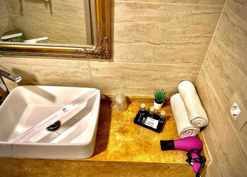 曼加利亚PLATINIUM Boutique Residence的浴室的柜台设有水槽和镜子