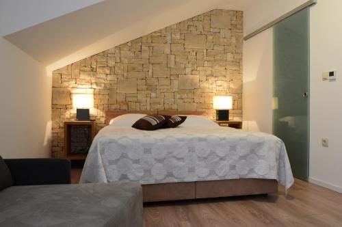 特罗吉尔特罗吉尔露西亚别墅公寓的一间卧室设有一张大床和石墙