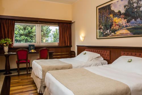 圣多纳托-米拉内塞桑塔芭芭拉酒店的酒店客房设有两张床和窗户。