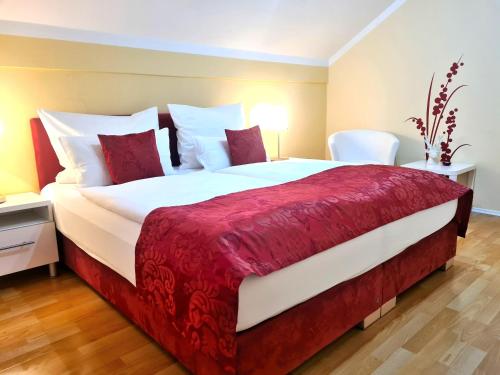 阿特湖畔翁特拉赫洛茵德尔公寓酒店的一间卧室配有一张带红色和白色床单的大床