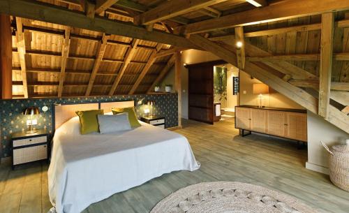 沙马雷勒ChamGaia off-grid eco-villa的一间带一张大床的卧室,位于一个拥有木制天花板的房间