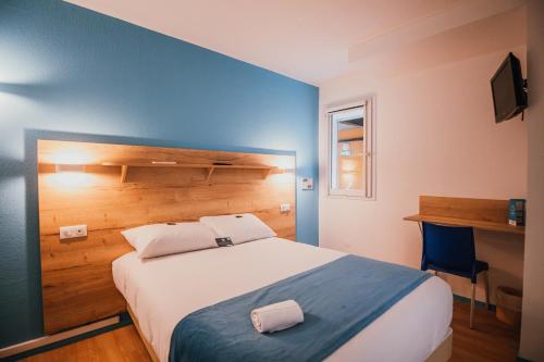 洛尔蒙Kyriad Direct Bordeaux Est Lormont的一间卧室设有一张蓝色墙壁的大床