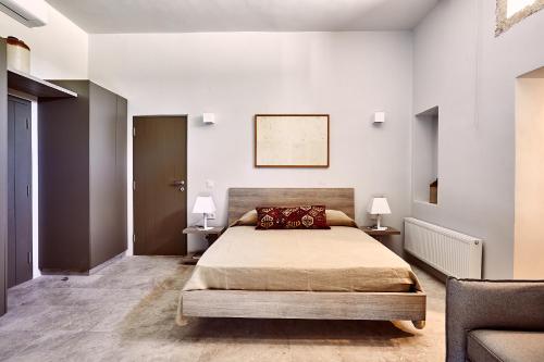 爱琴娜岛Nikolaou residence的一间卧室配有一张床和两张带台灯的桌子。