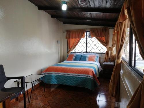 伊瓦拉Hostal Cumbres Andinas的一间设有床铺的卧室,位于带窗户的房间内