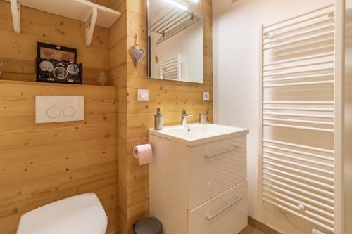 GénosLe cocon ideal pour six personnes avec vue sur les montagnes的一间带卫生间、水槽和镜子的浴室