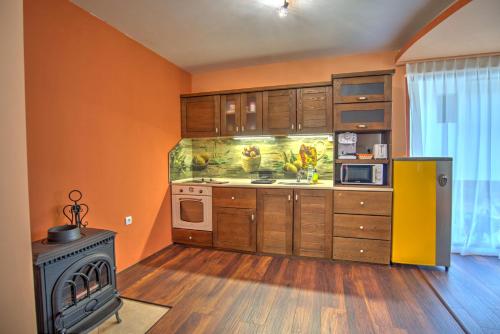 潘波洛沃Вила Capitalica Carpe的厨房设有橙色墙壁和炉灶。